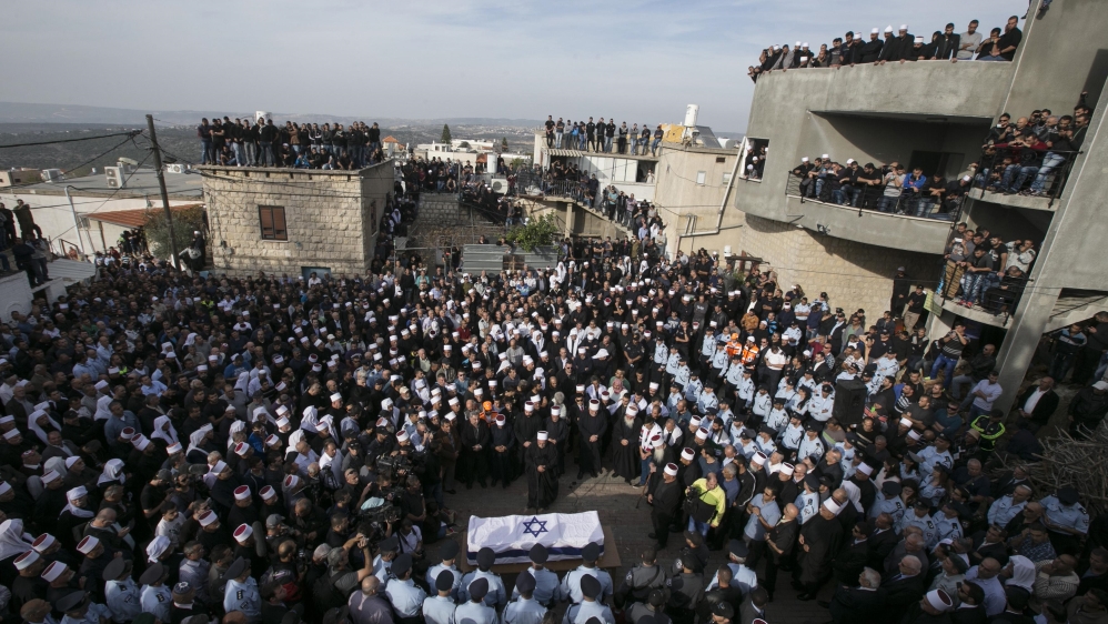 Mourners gather around the coffin of Israeli Druze police officer Zidan Nahad Seif during his funeral in Yanuh-Jat
