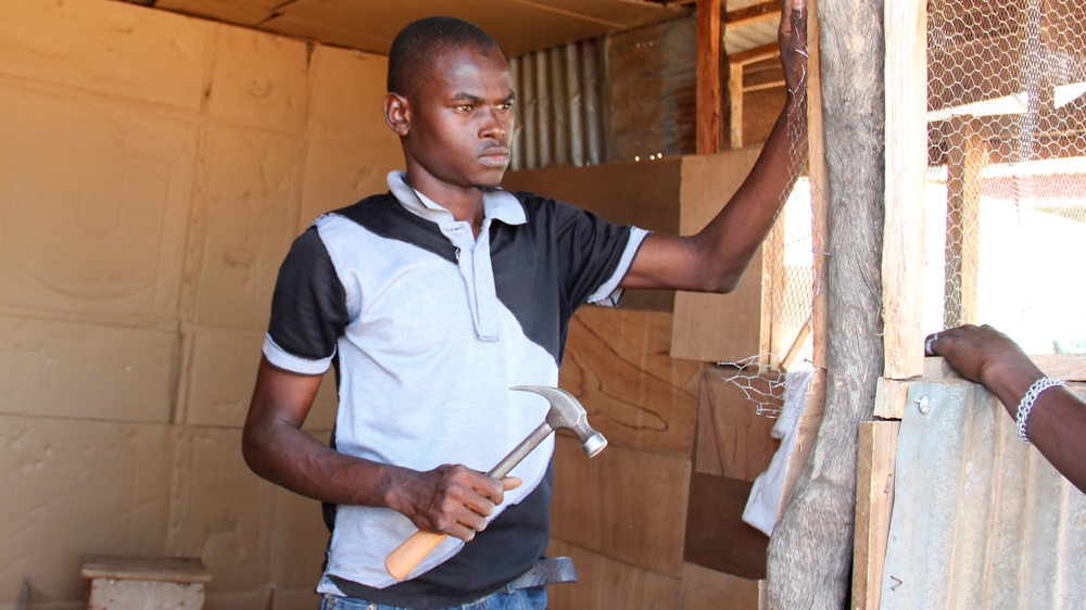 Abdullahi Sanusi's phone shop was blown apart in the blast. He is now rebuilding it with the help of friends [Femke van Zeijl/Al Jazeera] 