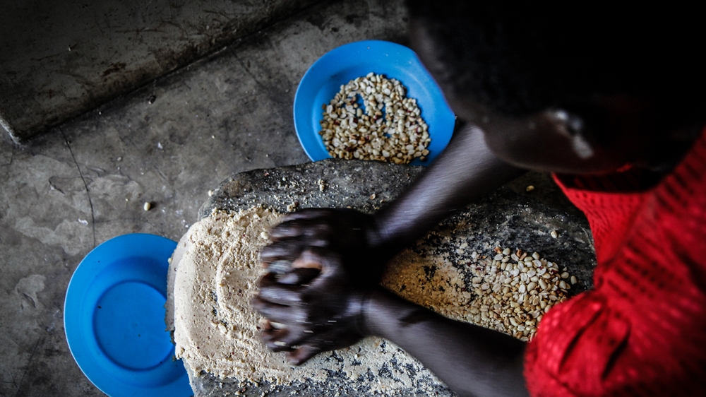 Grace and her family survive off a skill she learned in the bush - preparing waragi, a potent Ugandan brew made from yeast, sugar, water, groundnut paste and tea leaves [Marc Ellison/ Al Jazeera] 