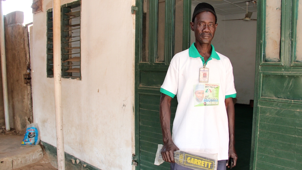 Umaru Ibrahim, and other volunteers like him, use metal detectors to check visitors at mosques and churches across Yola [Femke van Zeijl/Al Jazeera]
