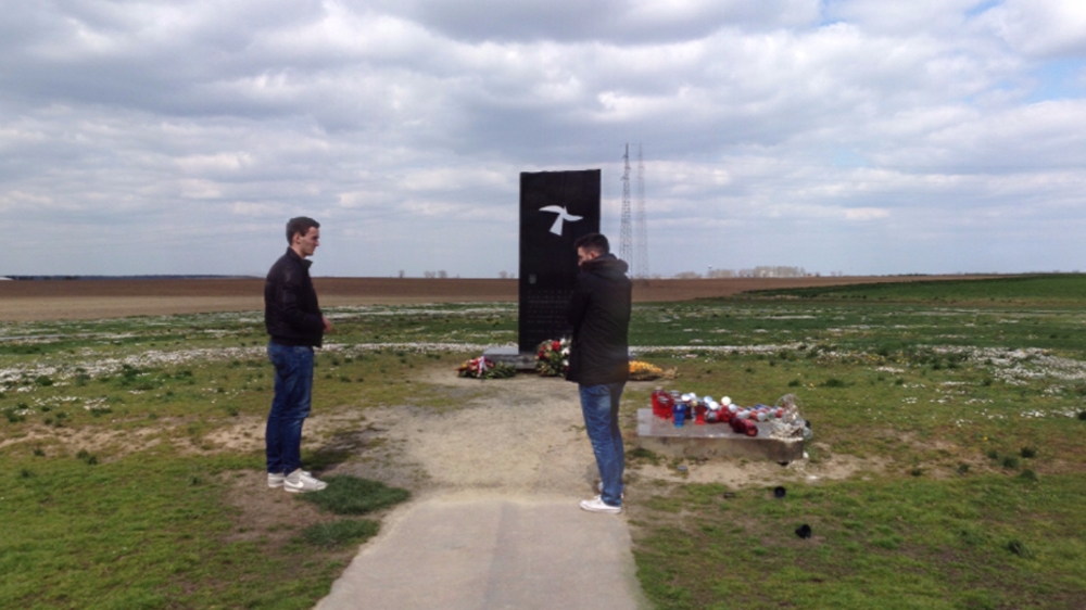The two friends pay their respects at the memorial that marks the mass grave of those killed in the Vukovar massacre [Coen van de Ven/Al Jazeera]
