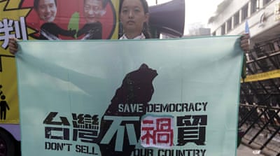 An activist protests against the meeting outside the Ministry of Economic Affairs in Taipei [Reuters]