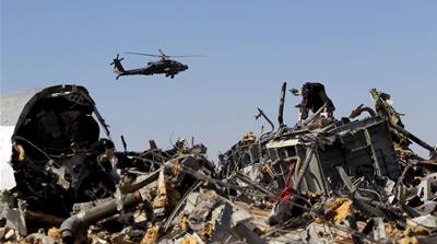 File photo shows an Egyptian military helicopter flying over debris from a Russian airliner which crashed at the Hassana area in Arish city