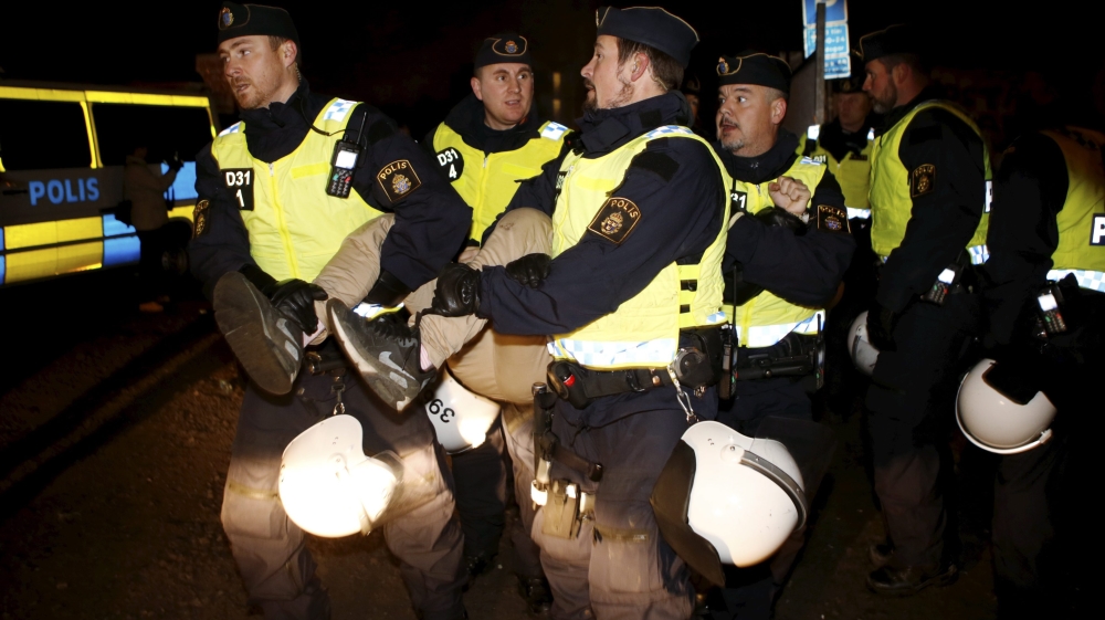 Police officers evict migrants from an illegal camp in Sweden