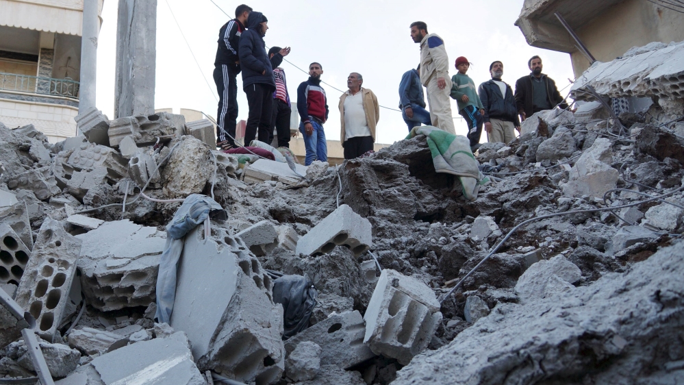 Residents inspect a damaged site from what activists said were airstrikes carried out by the Russian air force in Nawa city, Deraa, Syria