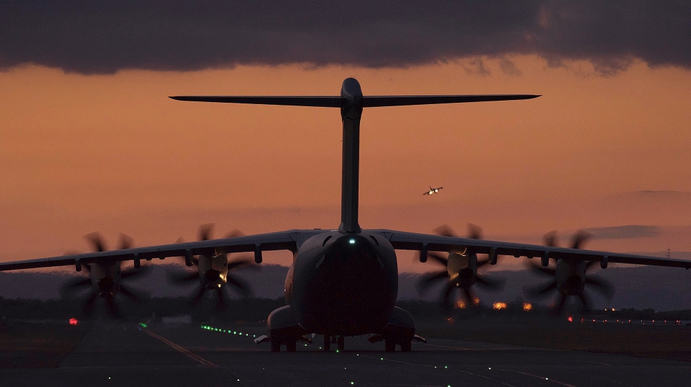 A fighter jet in the background landing as a transport aircraft is seen on the ground at the RAF Akrotiri, a British air base near the coastal city of Limassol, Cyprus [AP]