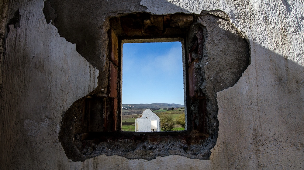 A view from an open window shows the skeleton of an abandoned home in Hade, where residents live on the fringes of the expanding Sibovc coal mine, a few kilometres away [Valerie Plesch/Al Jazeera]