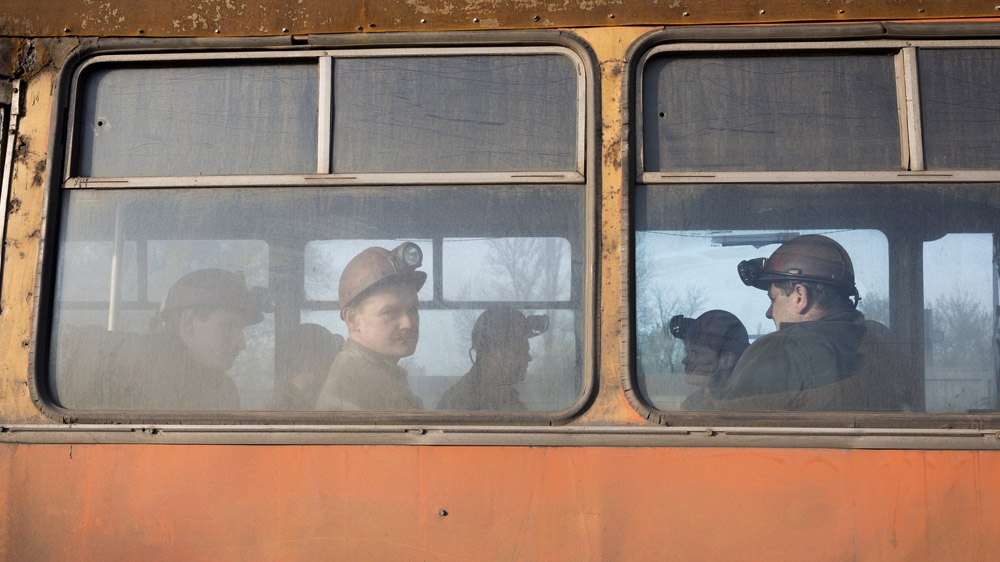 Miners on the bus to go to work in the early hours of the morning in Makeevka, a mining town on the outskirts of Donetsk. [Janos Chiala and Tali Mayer/Al Jazeera] 