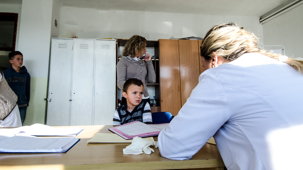 Diar Preniqi, six, speaks to a nurse from the Kastriot municipality family health clinic at his school in the village of Hade. Doctors and nurses recently implemented a policy to provide free medical check-ups to all pupils living in the municipality twice a year [Valerie Plesch/Al Jazeera]
