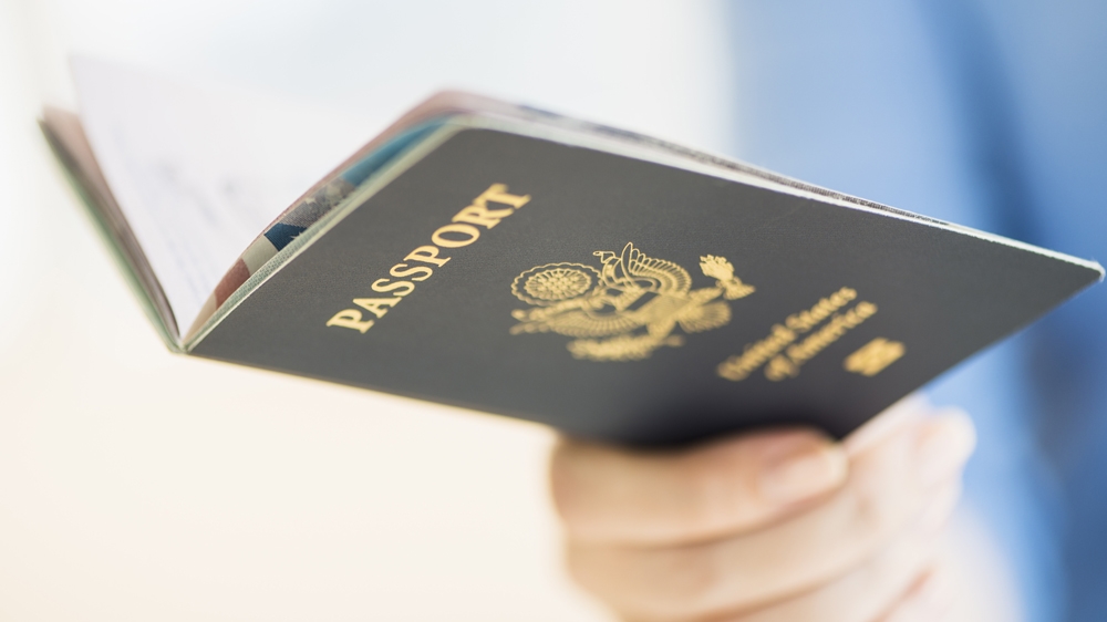 Close-up of woman's hand holding open passport.