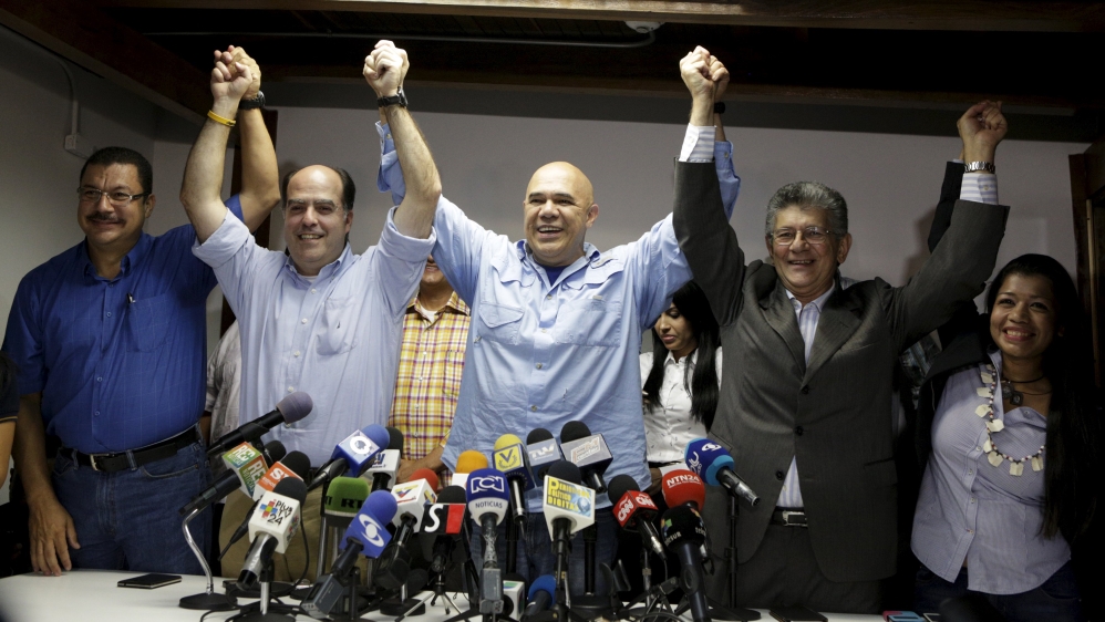 Secretary of Venezuela''s coalition of opposition parties holds hands with deputies Borges and Ramos Allup during a news conference in Caracas