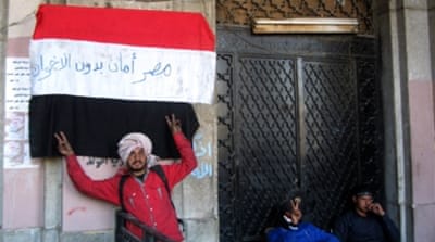An Egyptian protester flashes the sign of victory in front of the Mugamma in 2013 part of a growing campaign of civil disobedience around the country [AFP]