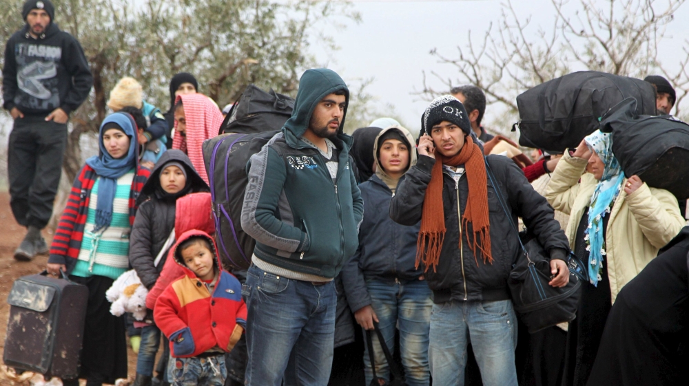 Displaced people, who fled the violence from Islamic State-controlled area of al-Bab, wait as they are stuck in the Syrian village of Akda to cross into Turkey