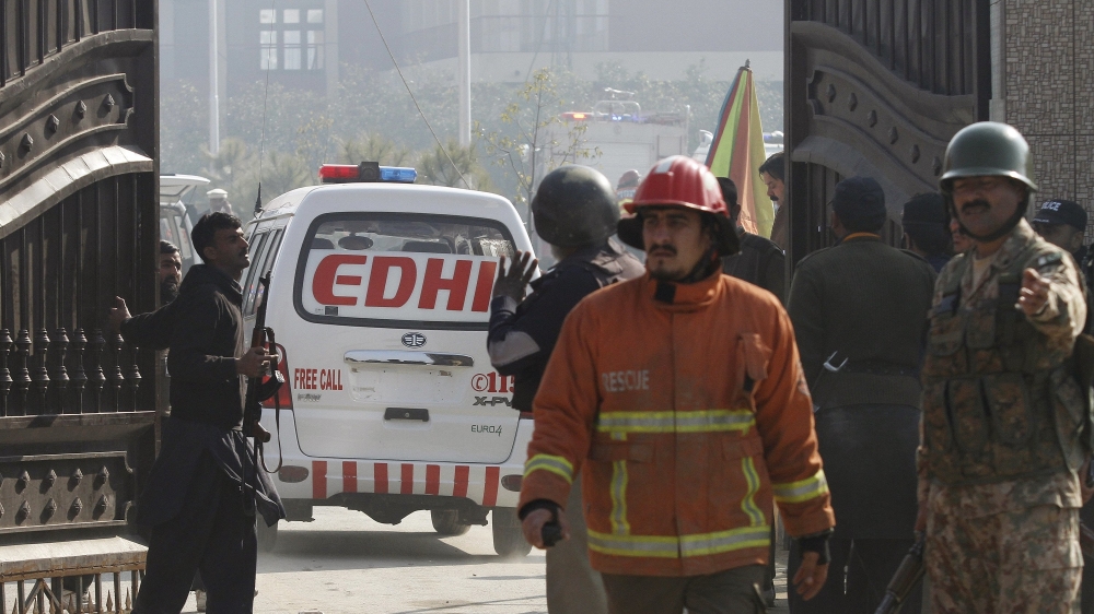 Soldiers and rescue workers stand as an ambulance enters Bacha Khan University, after a militant attack at the university, in Charsadda