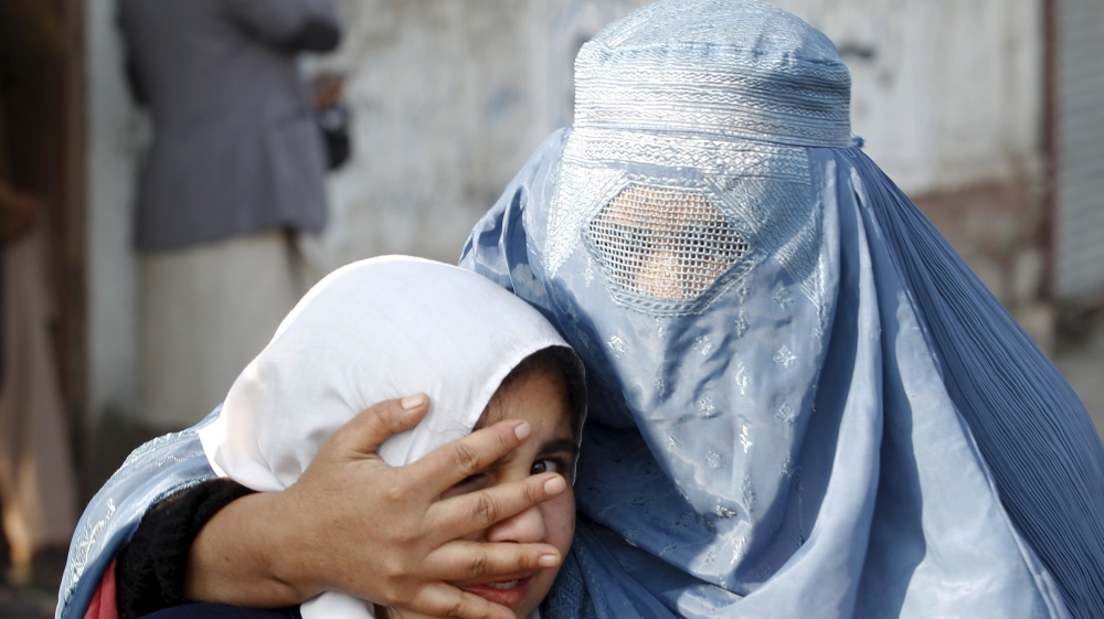 A woman holds her daughter''s head as they walk away after a blast near the Pakistani consulate in Jalalabad, Afghanistan [REUTERS]