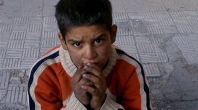 A child sitting on a broken pavement after hearing that Syrian authorities would allow civilians to leave the Palestinian neighborhood of Yarmouk in Damascus [AP]