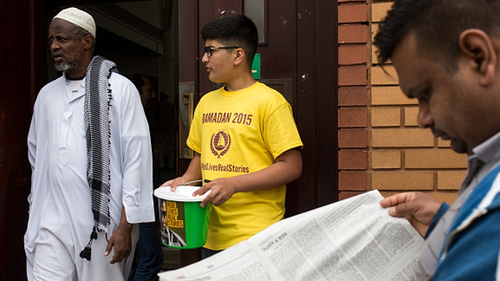 A man collects money for charity as people arrive at the East London Mosque to attend the first Friday prayers of the Islamic holy month of Ramadan in London, England [Getty]