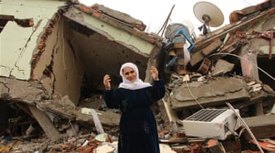 A resident stands on the rubble of a destroyed house in the mostly-Kurdish town of Silopi in southeast Turkey [AP]
