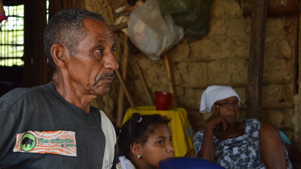 Andres Avelino Perez, 67, and his wife Virgilia Puche, 71, pictured with their 10-year-old granddaughter Maria, strongly oppose Cerrejon's relocation practice. [Fredrik Brogeland Laache/Al Jazeera]