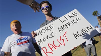 Supporters of Trump point and scream at an anti-Trump demonstrator holding a sign during a Trump campaign rally in Fountain Hills, Arizona. [Reuters]