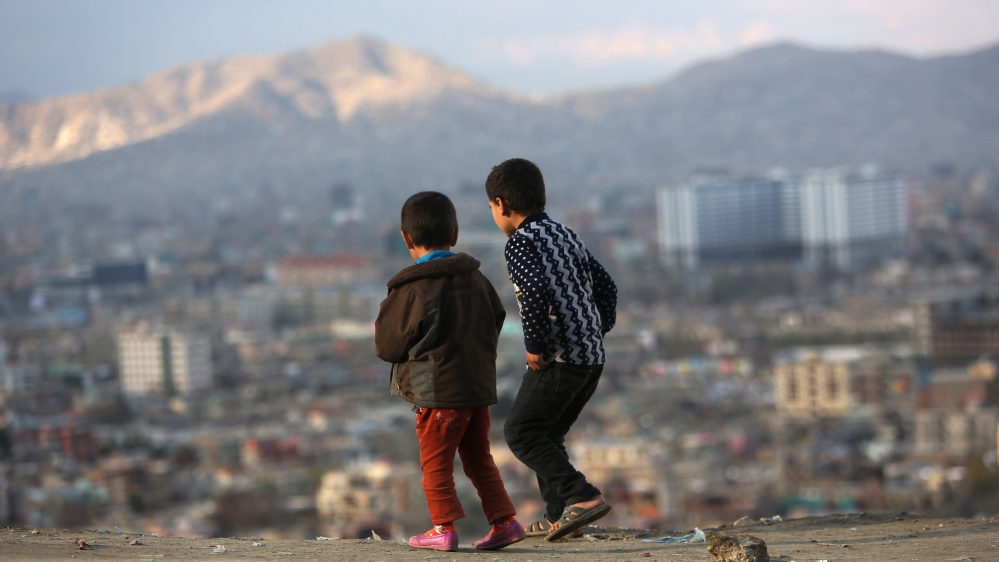 Afghan boys look at the view of Kabul city, Afghanistan [AP]