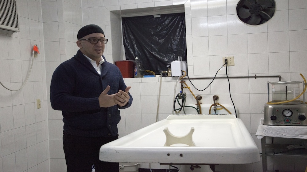 'I tell families, we must never do to a dead body something we wouldn't do to a living one,' says Kargi. The deceased's body is washed carefully with warm water [Mir Ubaid/Al Jazeera]