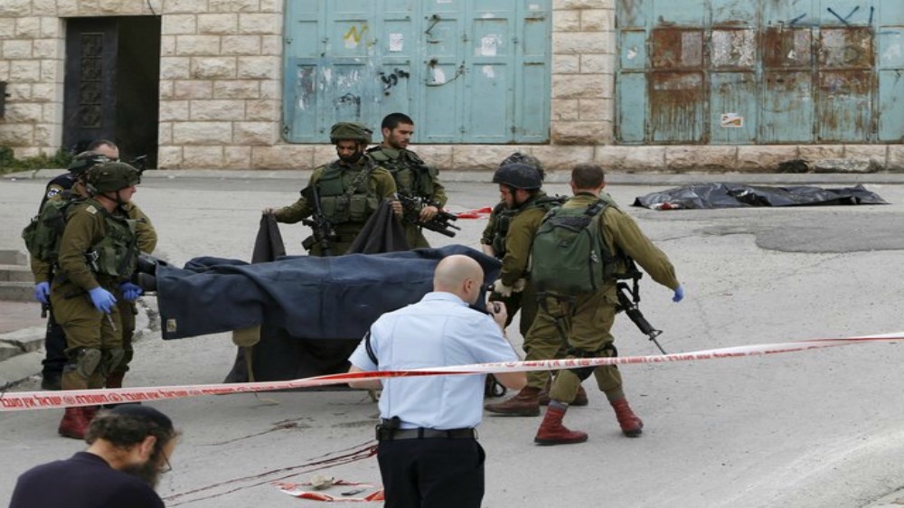 Israeli soldiers carry the dead body of one of two Palestinians, whom the Israeli military said were shot dead by Israeli troops after they attacked an Israeli soldier