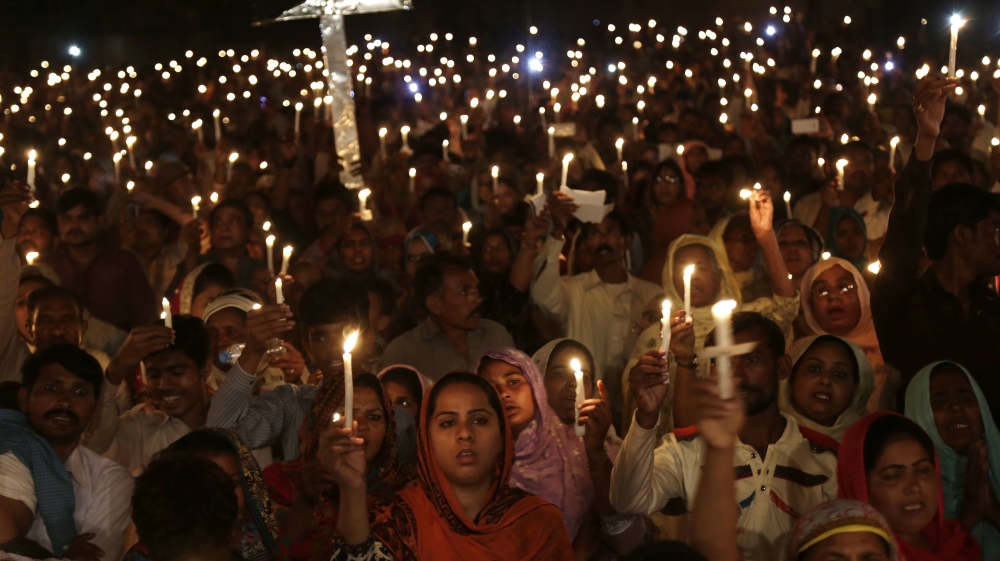 Pakistani Christians hold candles during a vigil for victims of a deadly suicide bombing in Lahore, Pakistan [AP]