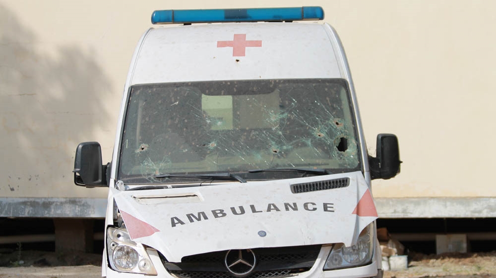 A bullet-riddled ambulance sits by a destroyed hospital [Justin Lynch/Al Jazeera] 