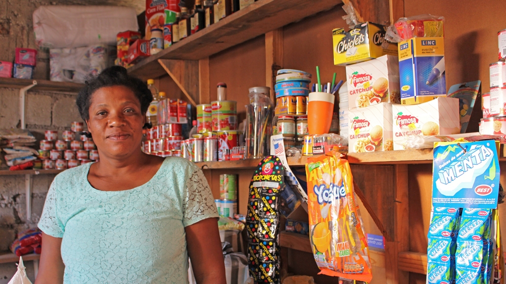 Altagrace Francois stands in her shop where she sells everything from combs to rice to coffee and candy [Stephanie Ott/Al Jazeera] 