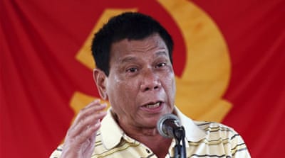 Presidential candidate Mayor Rodrigo Duterte speaks in front of a communist rebel group New People's Army (NPA) flag [Reuters]