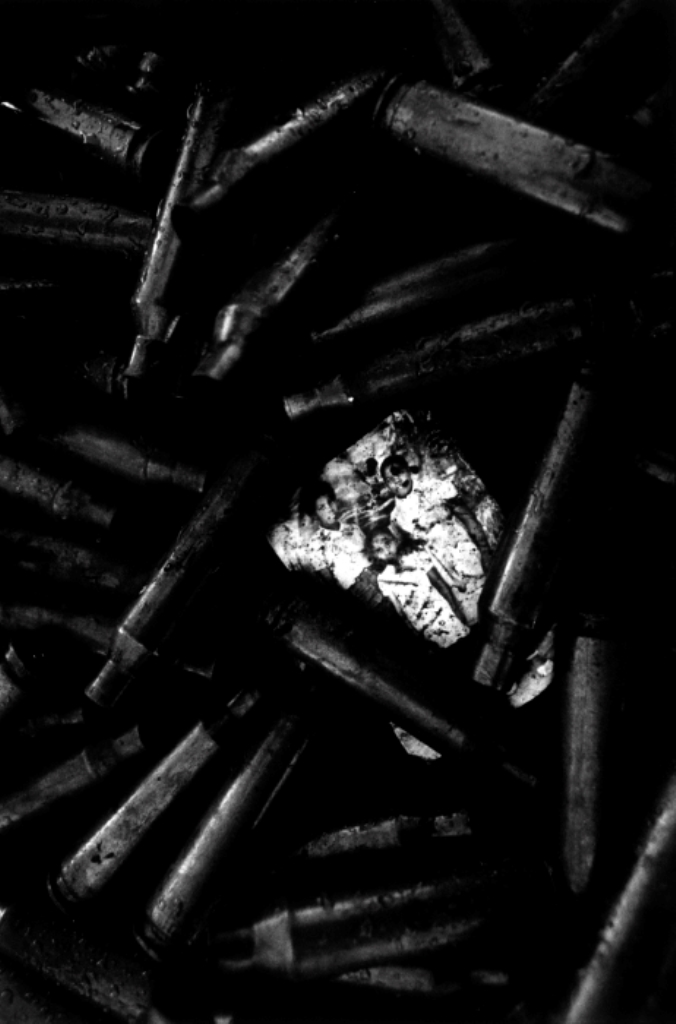 Shell cases frame a family photograph [Jack Picone/Al Jazeera]