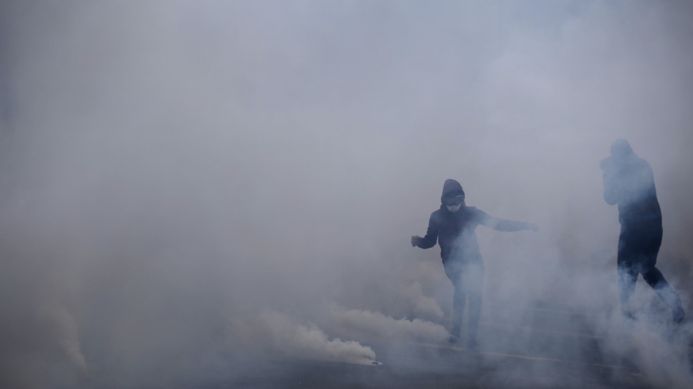Youths take cover from tear gas during a demonstration in Nantes [Reuters]