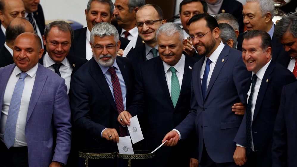 Binali Yildirim, the likely new leader of Turkey''s ruling AK Party, poses with MPs as he votes during a debate at the Turkish parliament in Ankara