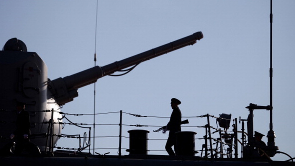 A Russian Navy member stands guard on the deck of a Russian nuclear-powered missile cruiser docked in the Cypriot port of Limassol [AFP]