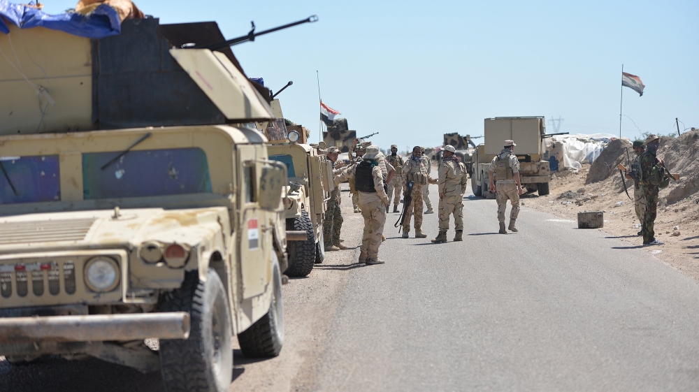 Iraqi soldiers with Shiite fighters gather on the outskirts of Fallujah
