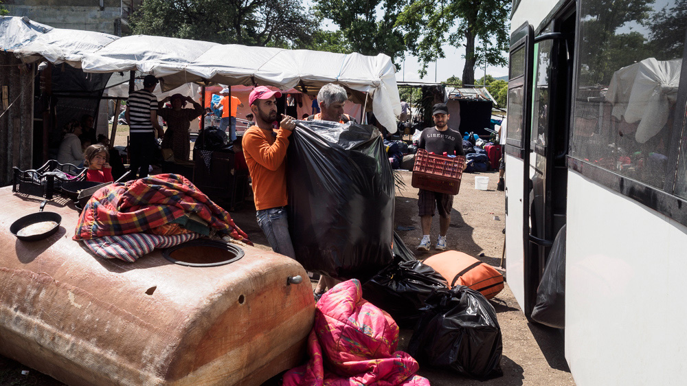 Refugees prepare to board buses that will take them to newly opened camps [Lazar Simeonov/Al Jazeera]