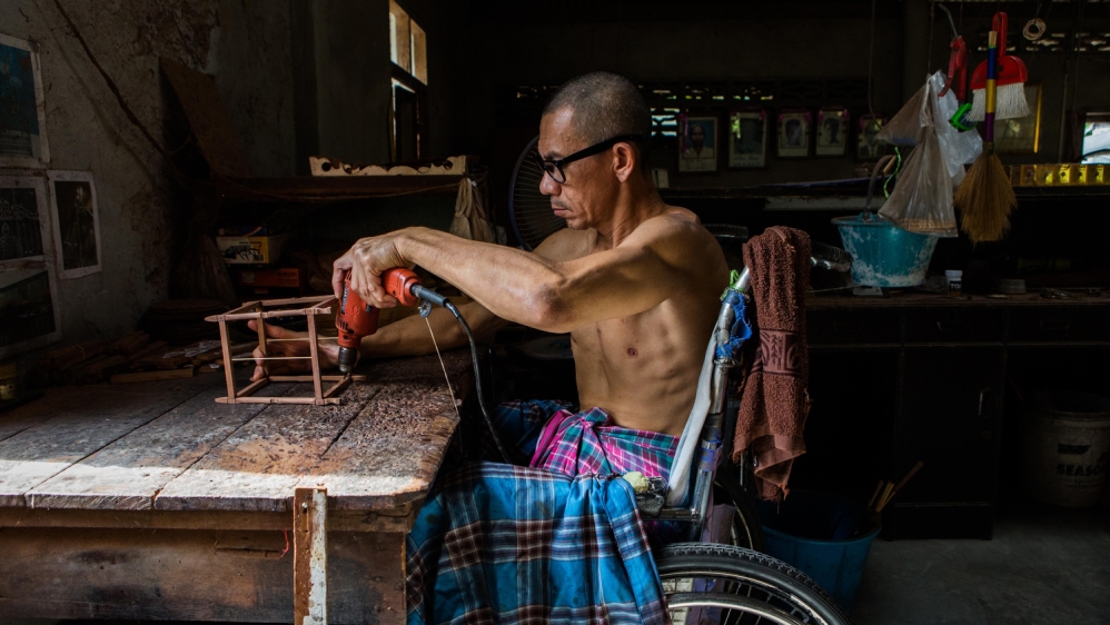 Wan Chai, who was shot while driving by unidentified gunmen 12 years ago, leaving him paralysed [Amanda Mustard/Al Jazeera]