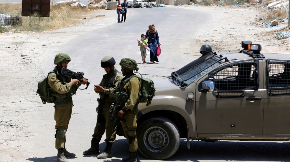 Israeli soldiers stand guard at the entrance of Yatta near the West Bank city of Hebron