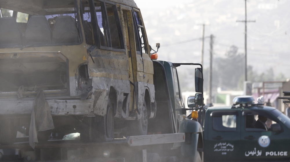 An Afghan police vehicle stands beside the bus that was attacked by a suicide bomber in Kabul [EPA]