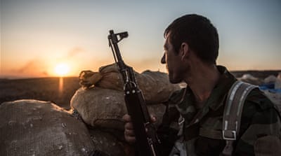 A Kurdish fighter looks out over the ISIL-held city of Mosul from the front line at Bashiqa [Al Jazeera]