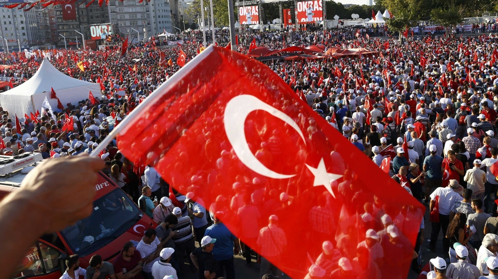 A man waves Turkey''s national flag as he with supporters of various political parties gathers in Istanbul''s Taksim Square