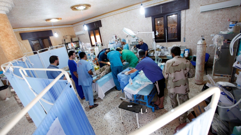 Doctors perform an operation on an injured soldier from forces aligned with Libya''s new unity government at a field hospital in Sirte