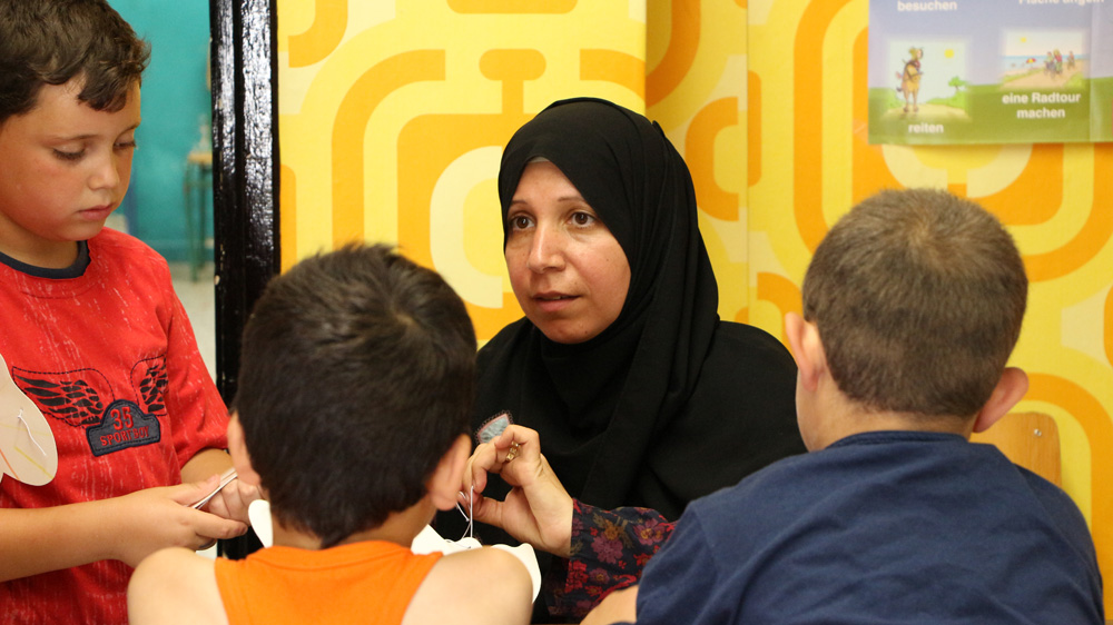 Abeer Mawad began teaching English to women and children in the playground armed only with a chair and an Ikea blackboard [John Psaropoulos/Al Jazeera]