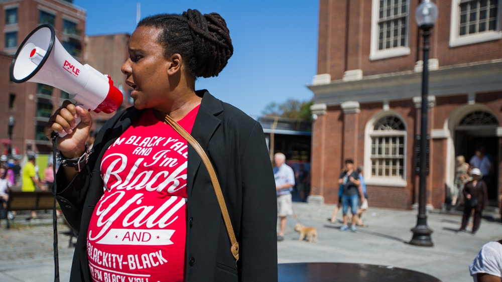 Nia Evans speaks to the crowd of protesters outside Faneuil Hall [Carolyn Bick/Al Jazeera] 