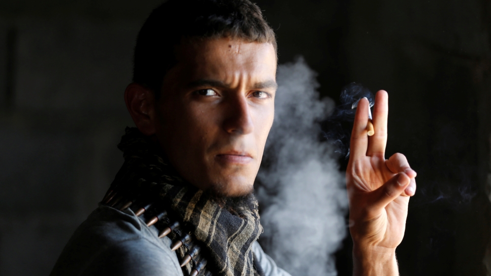 A fighter of Libyan forces allied with the U.N.-backed government smokes during a battle with Islamic State fighters in Sirte,