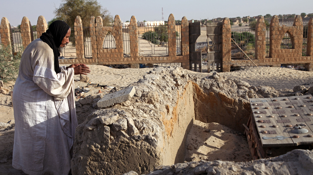Photo from 2014 shows caretaker of Timbuktu mausoleum praying at a damaged tomb [AP Photo/Baba Ahmed]