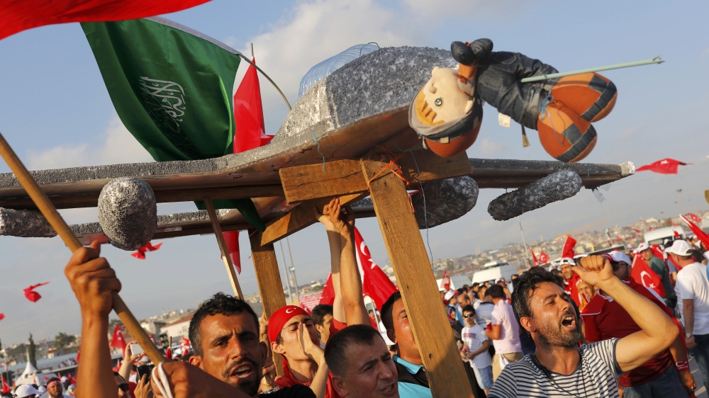 People hold a plane model with attached toy depicting opposition cleric in exile Gulen during the Democracy and Martyrs Rally in Istanbul