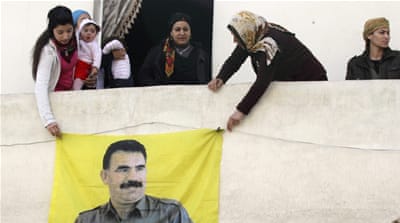 Kurdish women hang picture of Abdullah Ocalan, jailed leader of PKK, during celebration after it was reported that Kurdish forces took control of Kobani, in Aleppo
