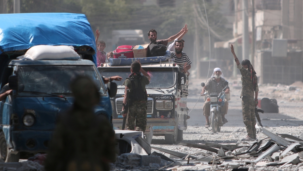 Syria Democratic Forces (SDF) fighters greet civilians who were evacuated by the SDF from an Islamic State-controlled neighbourhood of Manbij